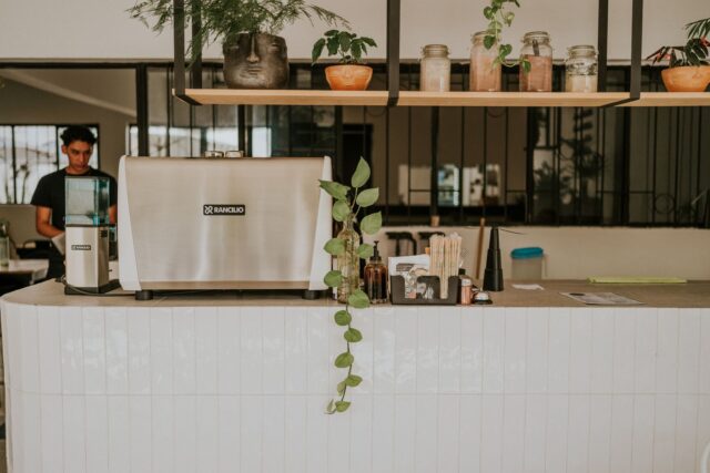 Masă de restaurant aranjată cu pahare, șervete și tacâmuri, pregătită înaintea serviciului