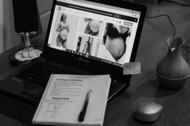 Caiet cu notițe și pix lângă un laptop, într-o zonă de studiu liniștită
